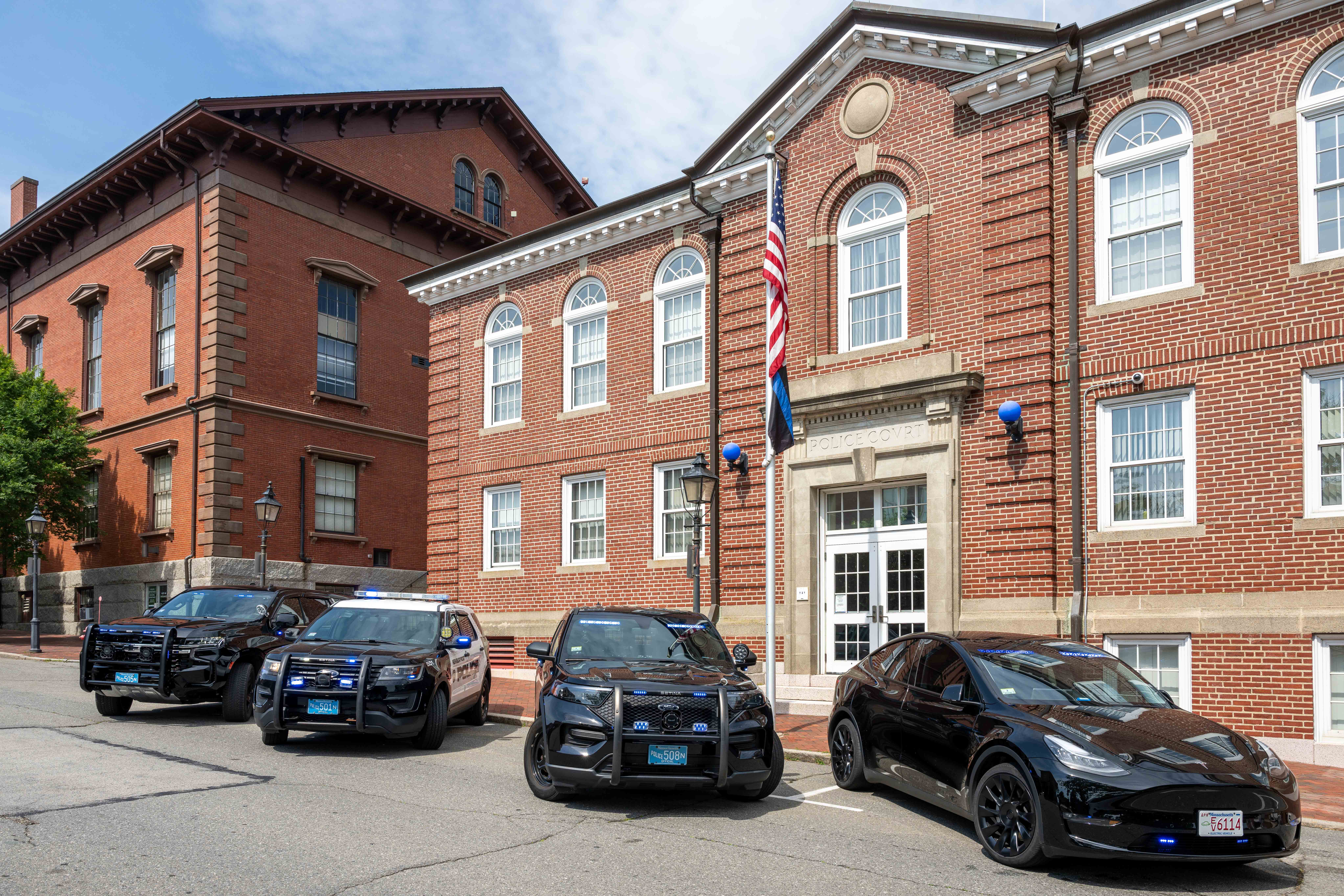 Exterior of the Newburyport Police Department with four police cruisers parked out front.